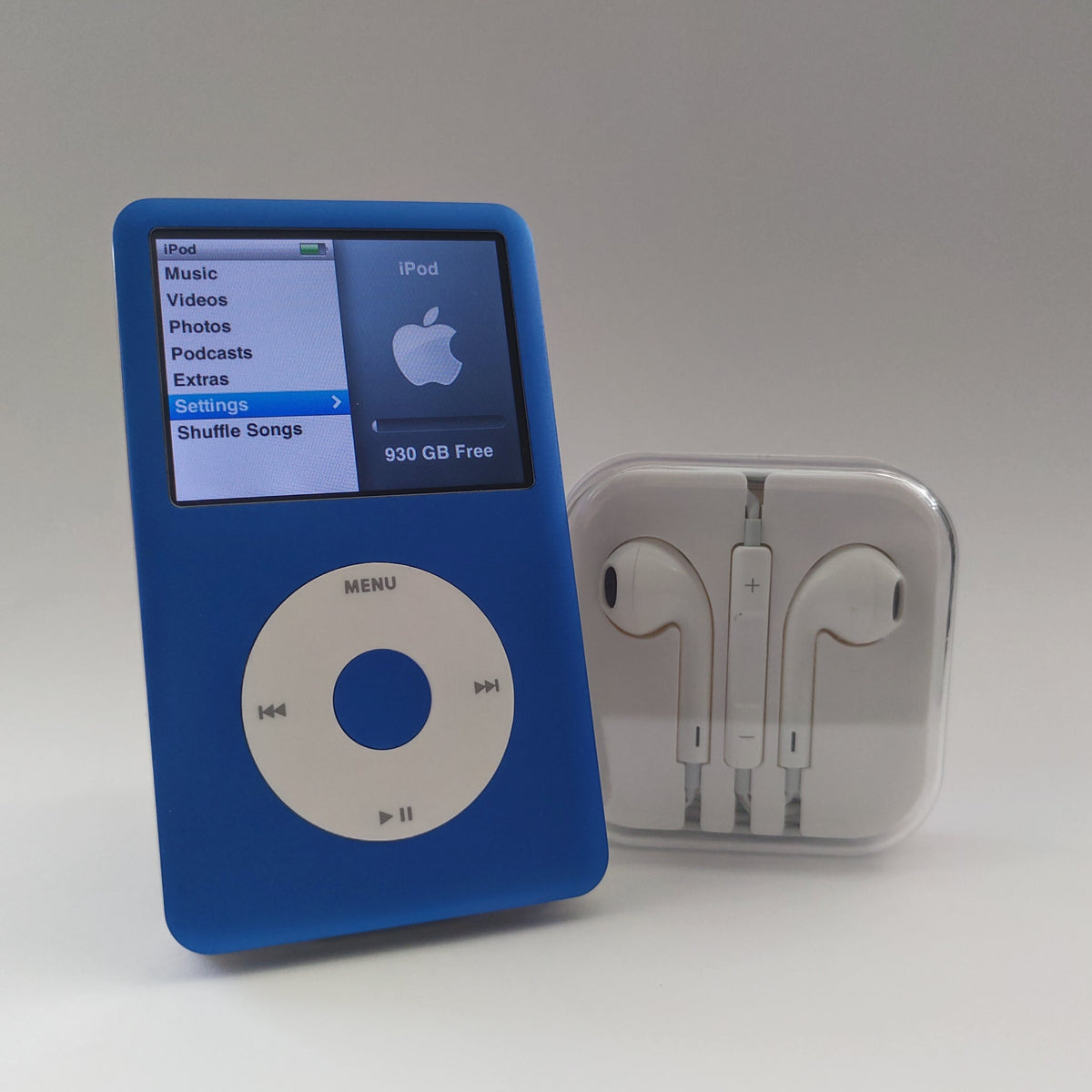Blue iPod Classic with a white click wheel displaying its main menu, together with white earphones