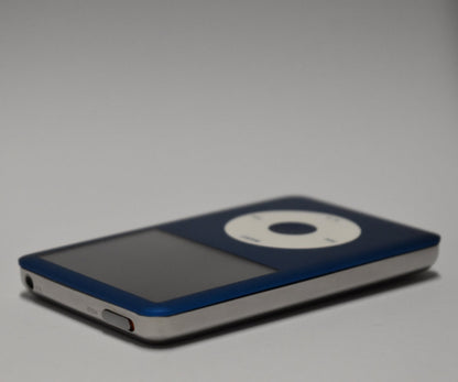 Angled view of a blue iPod Classic with a white click wheel and polished silver rear housing