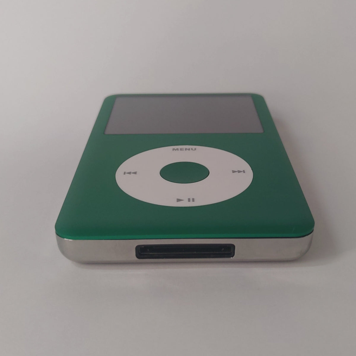 Green iPod Classic with a white click wheel and matching green centre button, viewed from the bottom edge