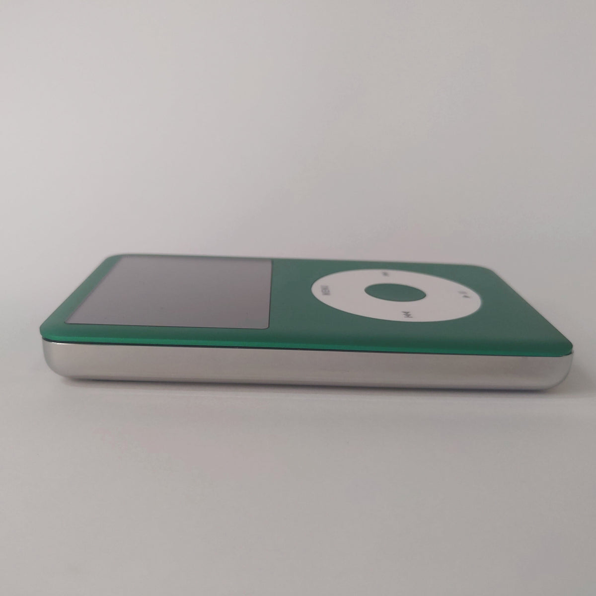 Side view of a green iPod Classic with a white click wheel and polished silver rear housing