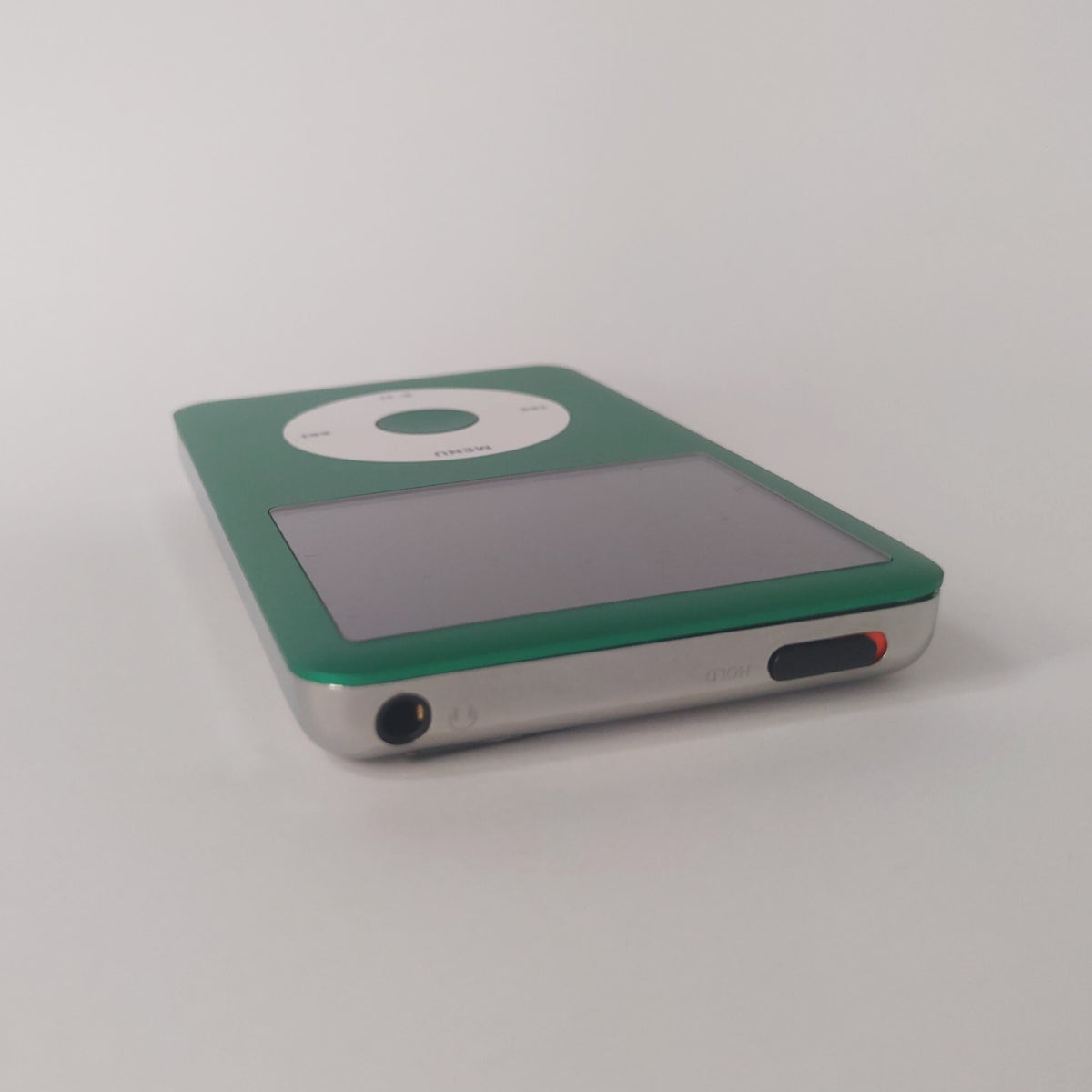 Green iPod Classic with a white click wheel and matching green centre button, viewed from the top edge