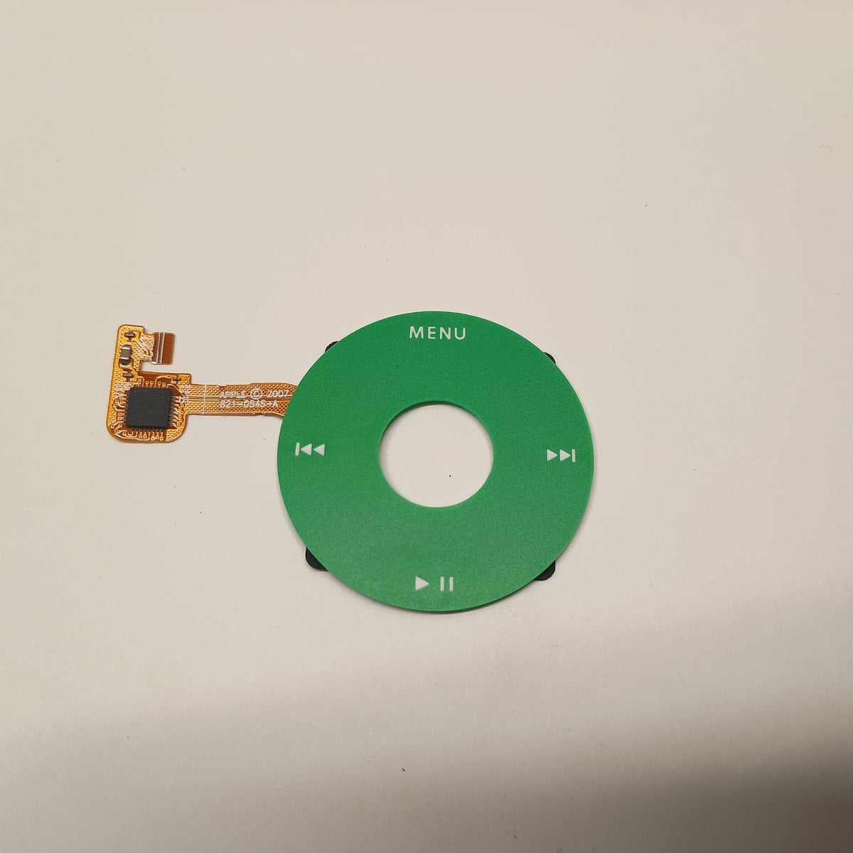 Green iPod Classic replacement click wheel with white control markings and an attached orange ribbon cable