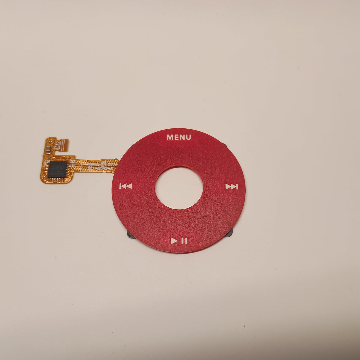 Red iPod Classic replacement click wheel with white control markings and an attached orange ribbon cable
