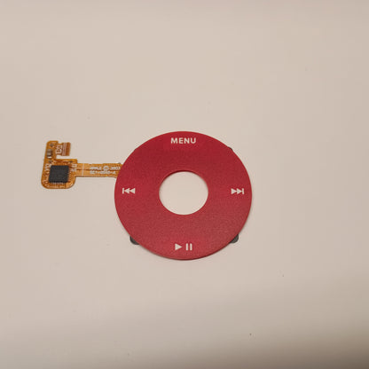 Red iPod Classic replacement click wheel with white control markings and an attached orange ribbon cable