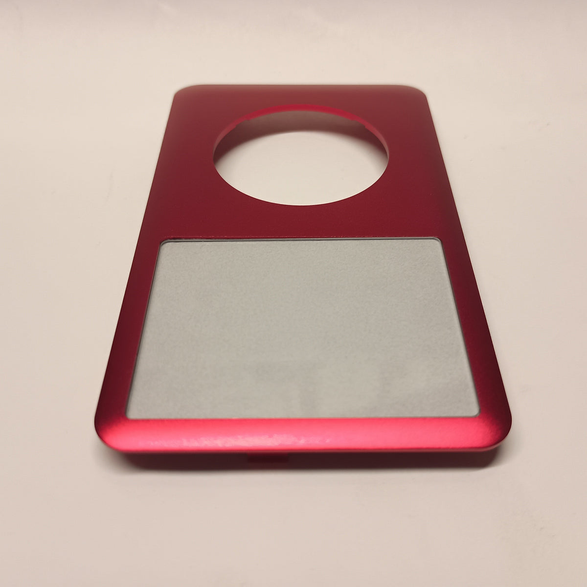 Red iPod Classic replacement front housing, viewed from the screen end at a low angle