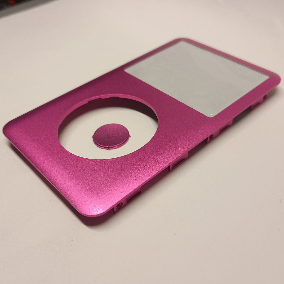 Angled view of a pink iPod Classic replacement front housing with a matching centre button