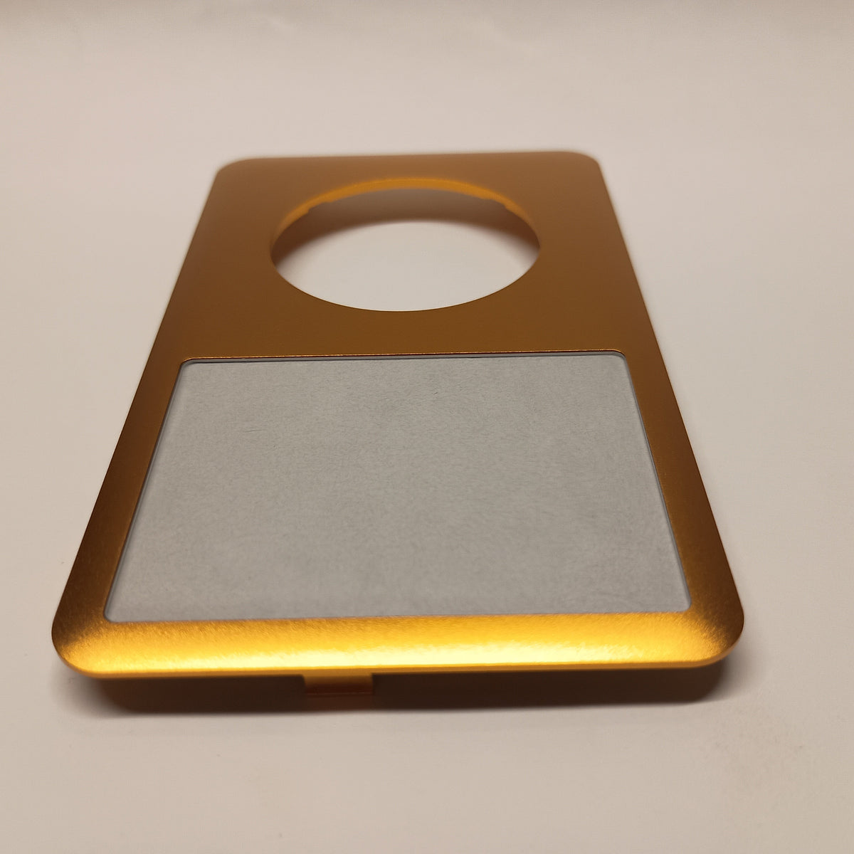 Gold iPod Classic replacement front housing, viewed from the screen end at a low angle