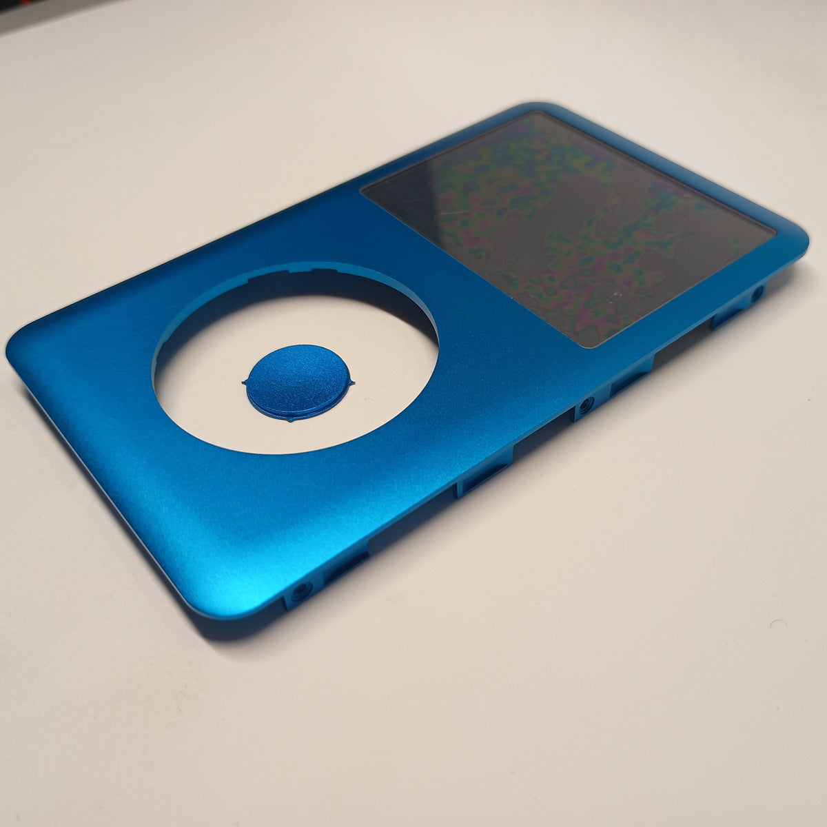 Angled view of a blue iPod Classic replacement front housing with a matching centre button