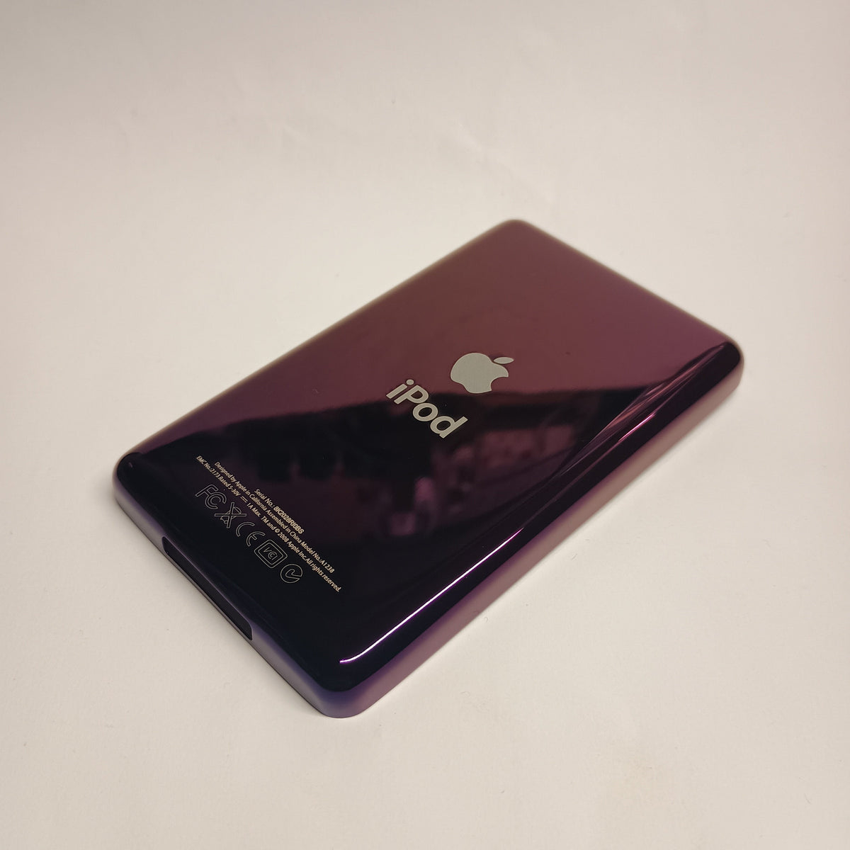 Angled view of a polished purple iPod Classic replacement rear housing with Apple and iPod engraving