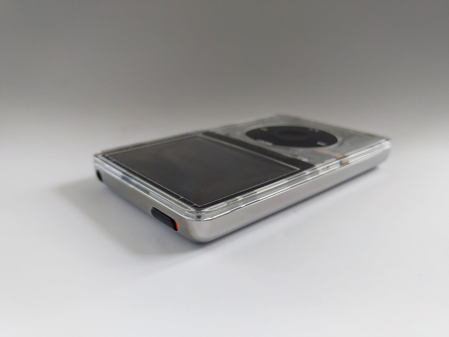 Custom transparent iPod classic with black click wheel and silver rear panel top corner view